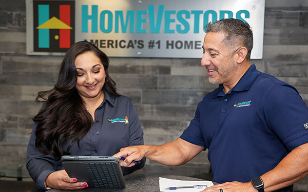 Homevestors employees looking at a tablet